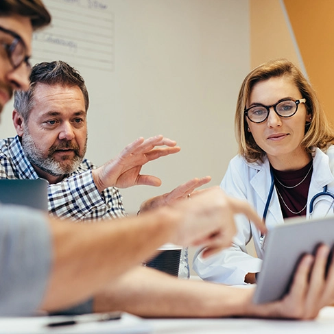 health professionals in a meeting looking at a tablet